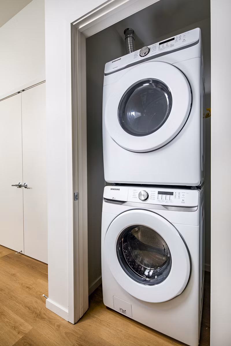 Laundry room with modern washers and dryers at 200 West Ocean Apartments