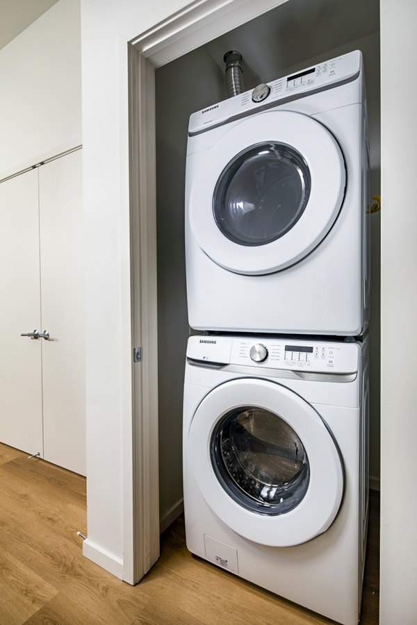 Laundry room with modern washers and dryers at 200 West Ocean Apartments