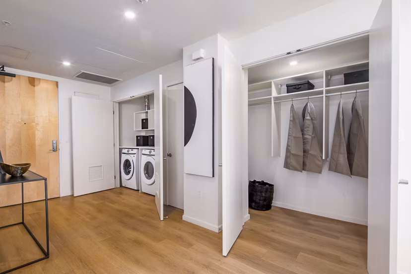 Laundry area with stacked washer and dryer in hallway closet at 200 West Ocean luxury apartments