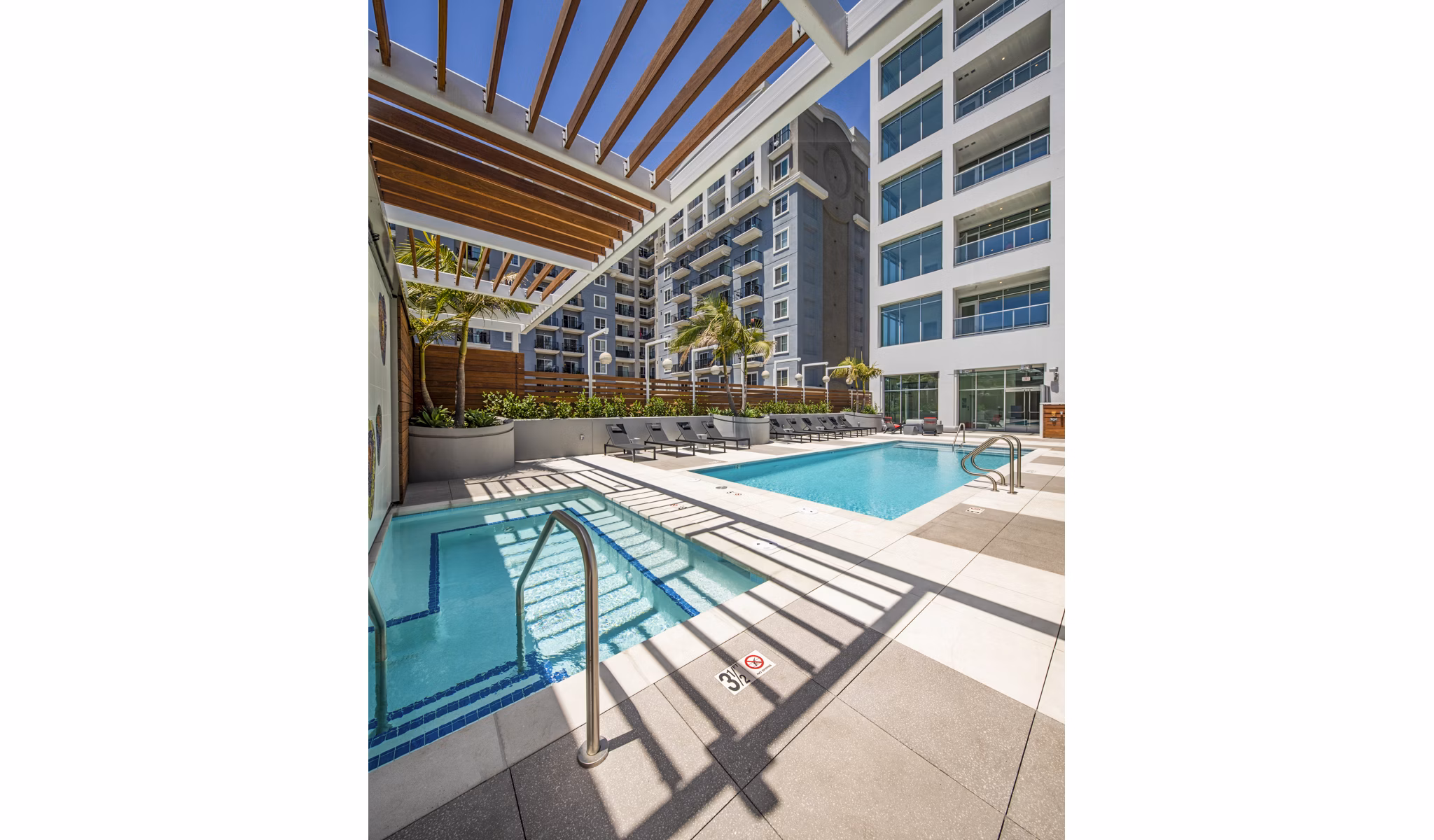 Modern outdoor pool with lounge chairs at 200 West Ocean Apartments, offering luxury amenities in a serene setting