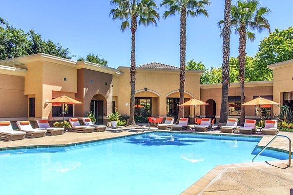 Luxury pool surrounded by lush greenery at Waterford Place Apartments, offering relaxation and leisure for residents