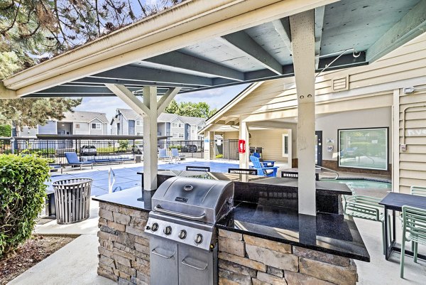 Grill area with outdoor seating at Avana Hamptons Apartments, ideal for social gatherings and leisurely dining in a serene setting