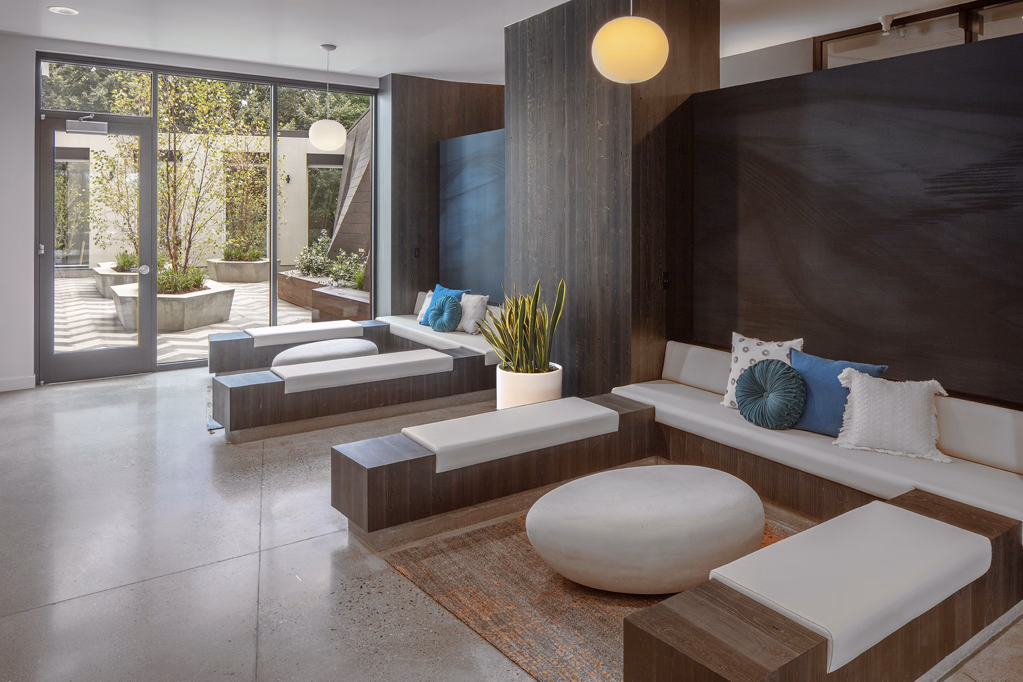 Clubhouse with modern seating and large TV at The Payton Apartments