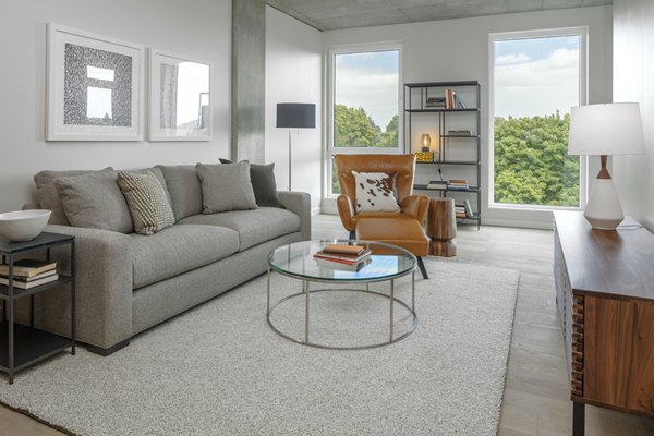 Spacious living room with modern decor and large windows at The Payton Apartments, luxury living by Greystar