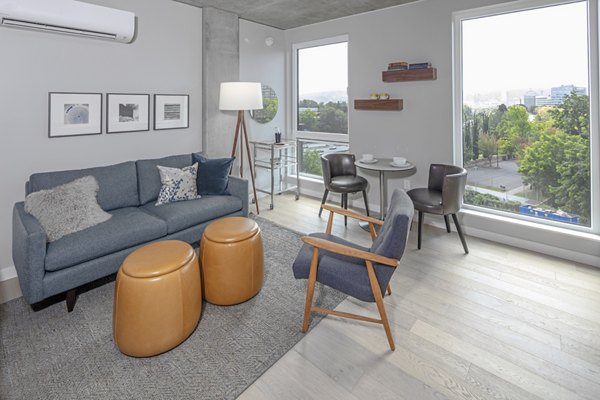 Spacious living room featuring modern decor and large windows at The Payton Apartments
