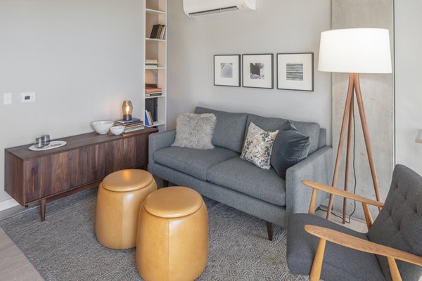 Modern living room with stylish decor and large windows at The Payton Apartments