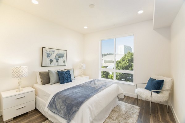 Modern bedroom with natural light and stylish design at One38 Apartments