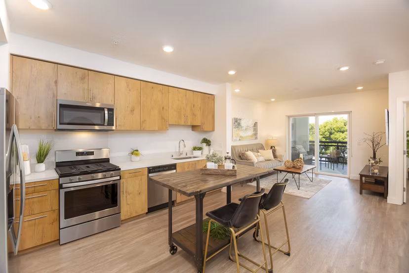 Modern kitchen with stainless steel appliances and marble countertops in One38 Apartments