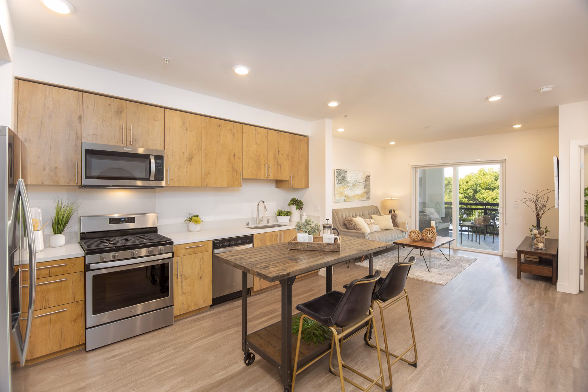 Modern kitchen with stainless steel appliances and marble countertops in One38 Apartments