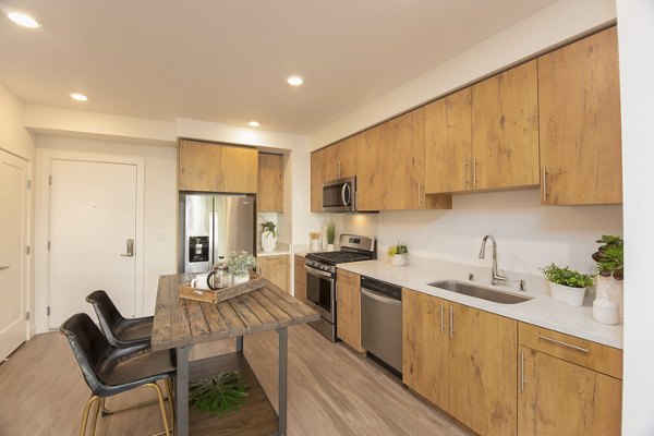 Modern kitchen featuring stainless steel appliances and granite countertops at One38 Apartments