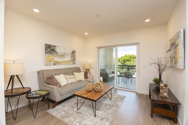 Spacious living room featuring modern decor and large windows at One38 Apartments, luxury Greystar property