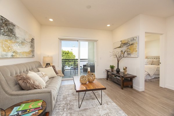 Living room with contemporary design and large windows at One38 Apartments