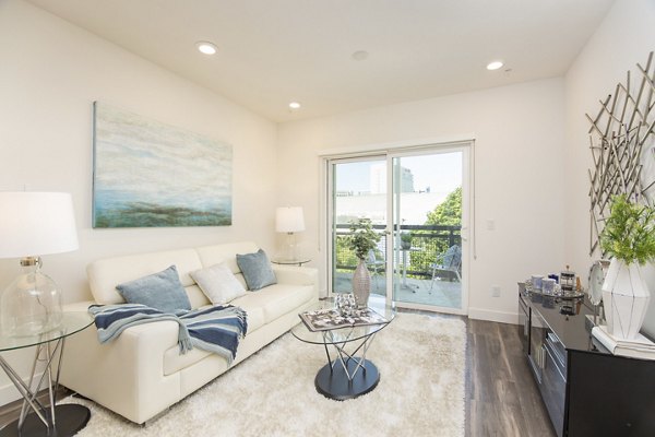 Stylish living room with modern furniture and abundant natural light at One38 Apartments