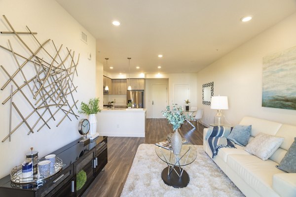 Living room with contemporary furnishings and large windows at One38 Apartments, offering a luxurious experience in urban living