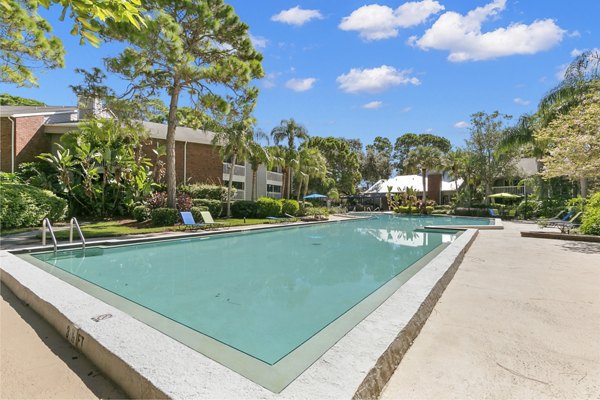 Relaxing pool with sun loungers at Avana Coachman Apartments, ideal for lounging and enjoying leisure time outdoors
