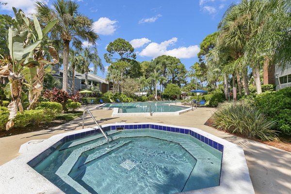 Resort-style swimming pool at Avana Coachman Apartments featuring elegant landscaping and comfortable lounge chairs