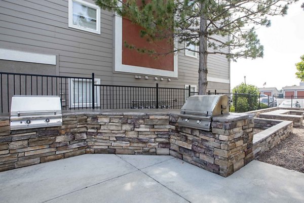 Grill area at Copper Terrace Apartments featuring outdoor seating and modern equipment Ideal for social gatherings in this luxury community