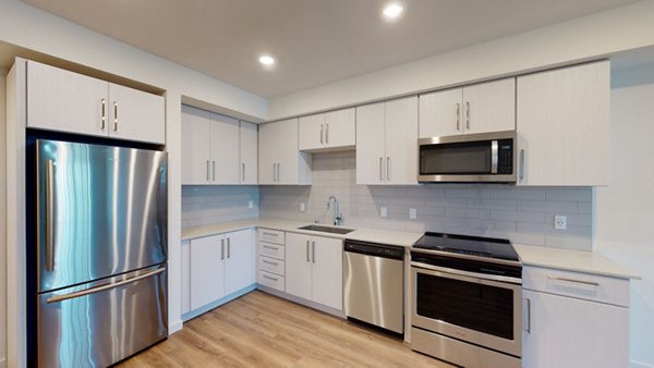 Kitchen with modern appliances and quartz countertops at The Exchange at Bayfront Apartments