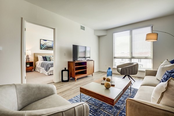 Bright living room with modern furnishings at The Exchange at Bayfront Apartments