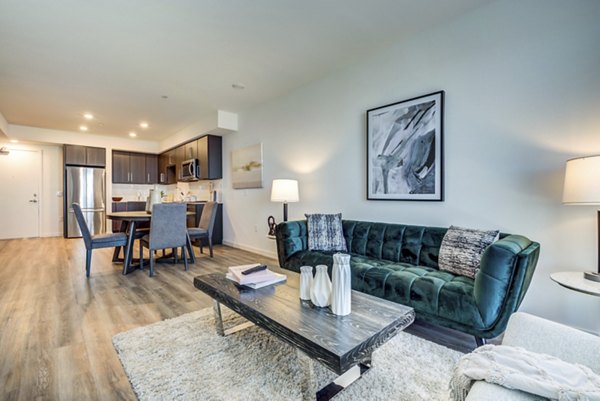 Spacious living room with modern furniture and bay views at The Exchange at Bayfront Apartments