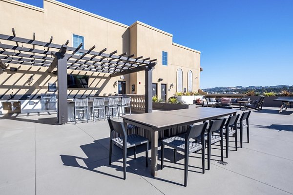 Outdoor grill area at The Exchange at Bayfront Apartments featuring modern amenities and seating for residents