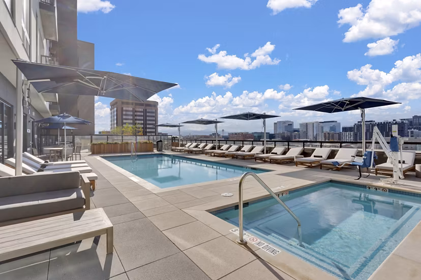 Resort-style pool area with loungers at The Fitzgerald Apartments