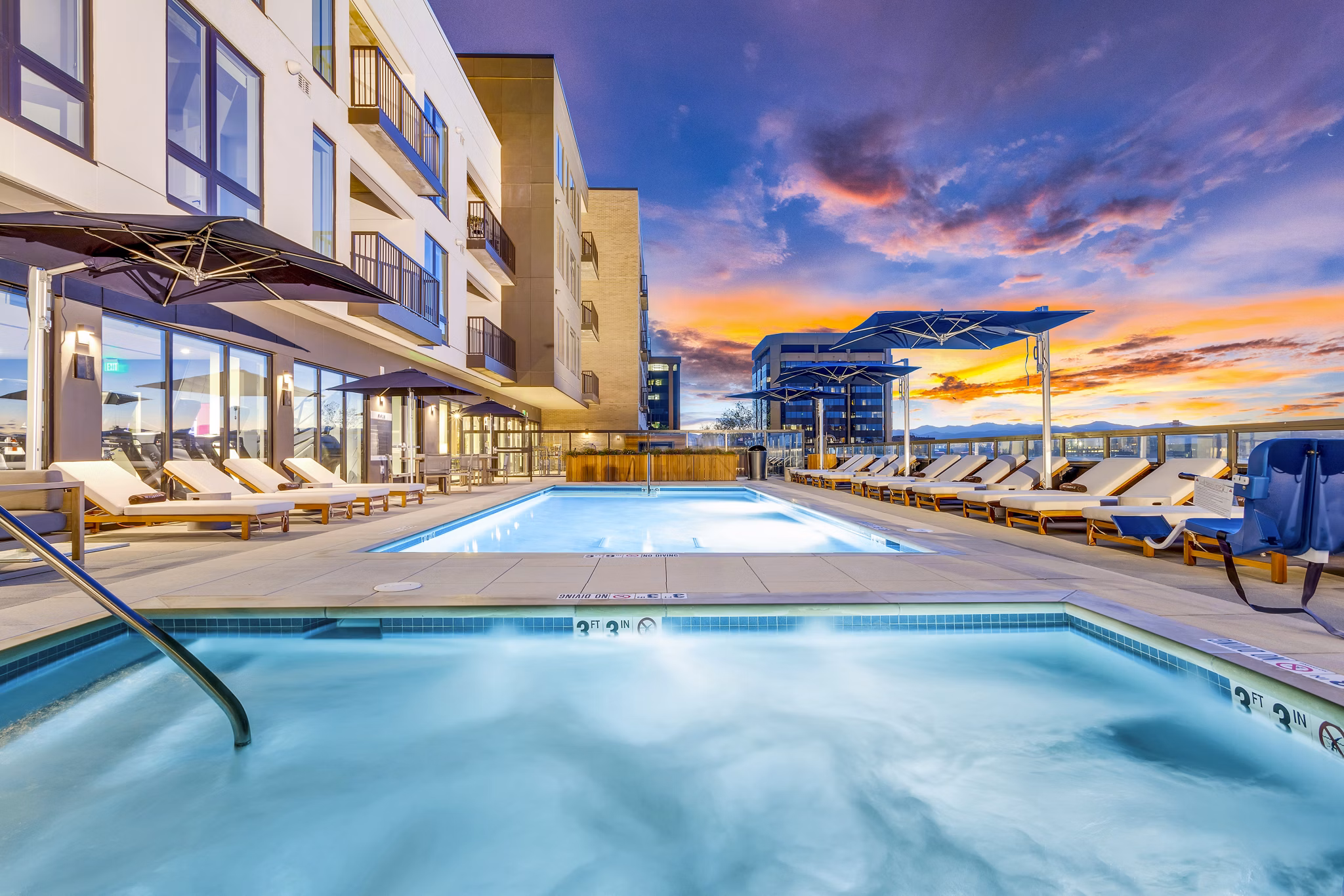 Resort-style pool area with loungers at The Fitzgerald Apartments