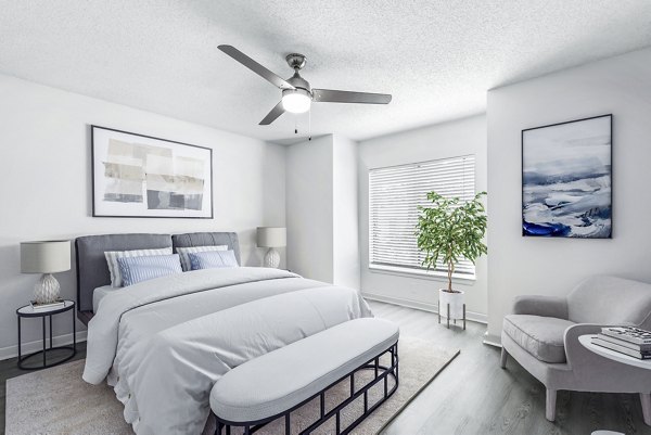 Cozy bedroom with modern decor and large windows at Avana Lakeview Apartments