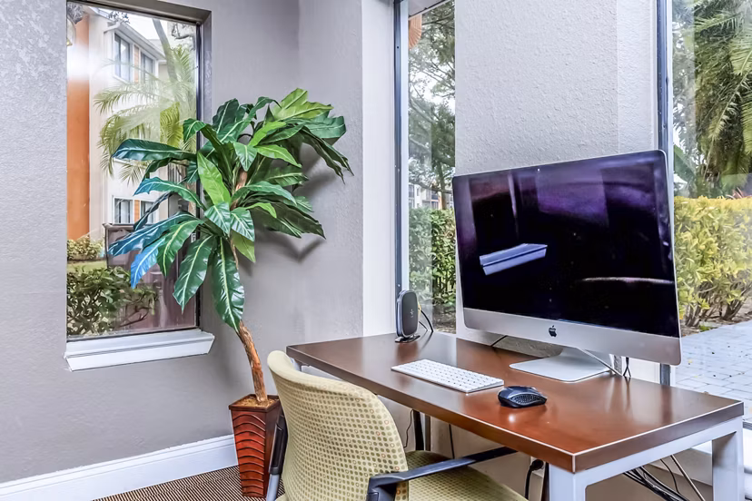 Avana Lakeview Apartments: Modern clubhouse business center with workstations and seating areas