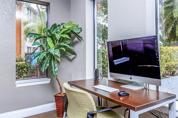 Avana Lakeview Apartments: Modern clubhouse business center with workstations and seating areas