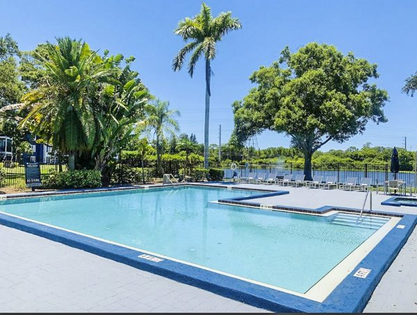 Relaxing pool area at Avana Lakeview Apartments with lounge chairs and landscaped surroundings