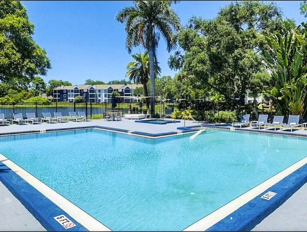 Infinity-edge pool with sun loungers at Avana Lakeview Apartments, offering luxury relaxation with stunning views