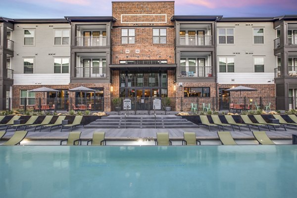 Sunlit pool area at Westhouse Apartment Flats with stylish lounge chairs and vibrant landscaping