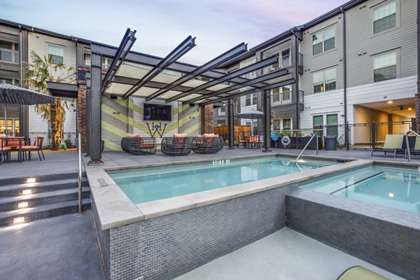 Resort-style pool at Westhouse Apartment Flats with luxury sun loungers and lush landscaping