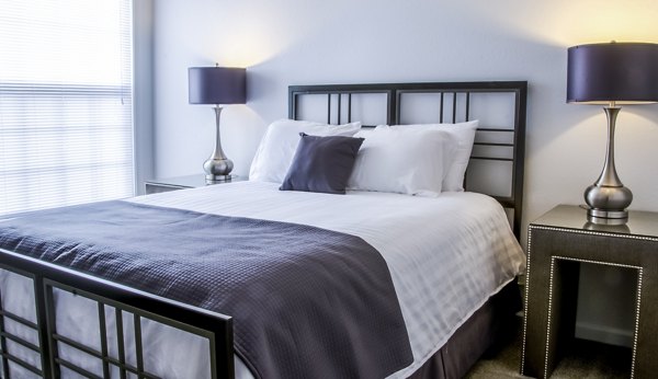 Modern bedroom featuring cozy seating area in Hidden Lakes Apartments