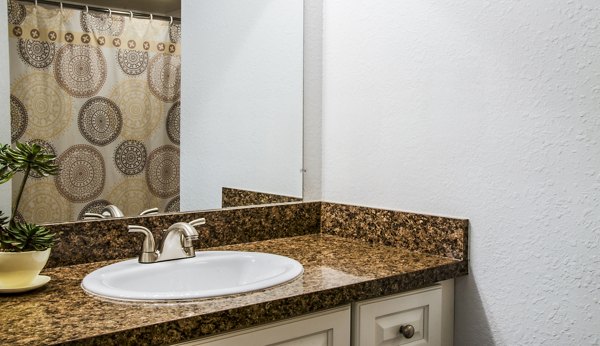 Bathroom with sleek fixtures and granite countertops at Hidden Lakes Apartments, offering luxury living in a serene environment