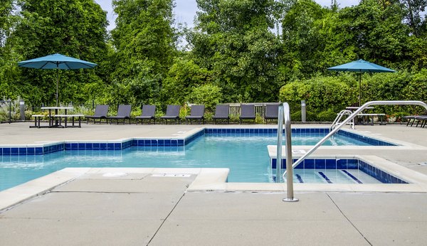 Sparkling outdoor pool at Hidden Lakes Apartments featuring comfortable lounge chairs and lush surroundings, perfect for relaxation and socializing