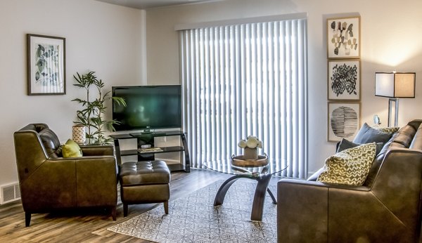 Spacious living room with modern furnishings in Oak Hill Apartments, featuring ample natural light and sleek design