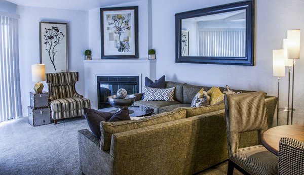 Modern living room featuring plush seating and large windows at Oak Hill Apartments