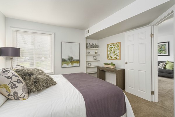 Contemporary bedroom with plush bedding and natural light at Shoal Creek Apartments