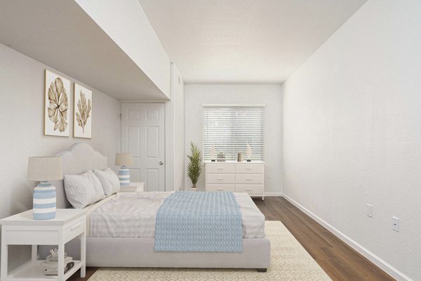 Cozy bedroom with plush bedding and large window at Woodland Meadows Apartments