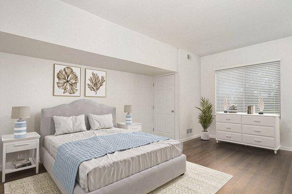 Elegant bedroom with soft lighting and modern furnishings at Woodland Meadows Apartments