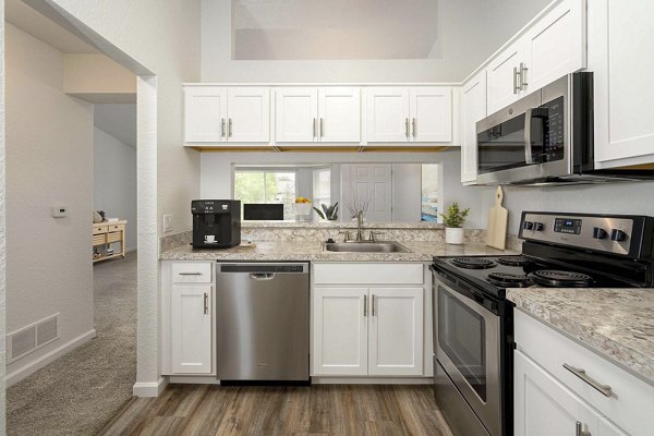 Kitchen featuring modern appliances and quartz countertops at Woodland Meadows Apartments