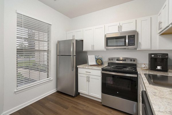 Modern kitchen with stainless steel appliances at Woodland Meadows Apartments