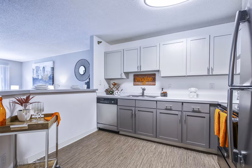Modern kitchen featuring stainless steel appliances and dark wood cabinets in Avana West Park Apartments