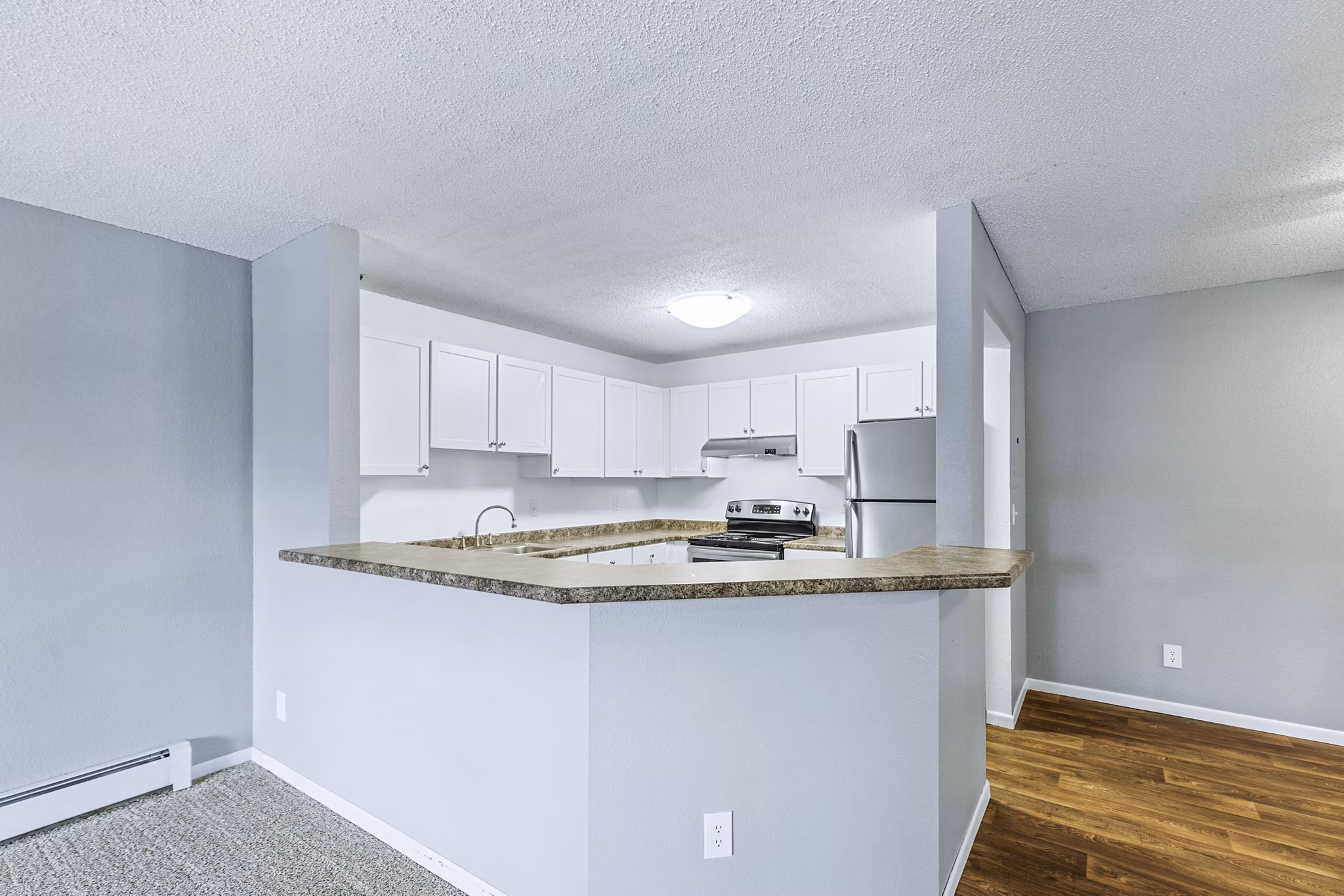 Contemporary kitchen with sleek countertops and modern appliances in Avana West Park Apartments