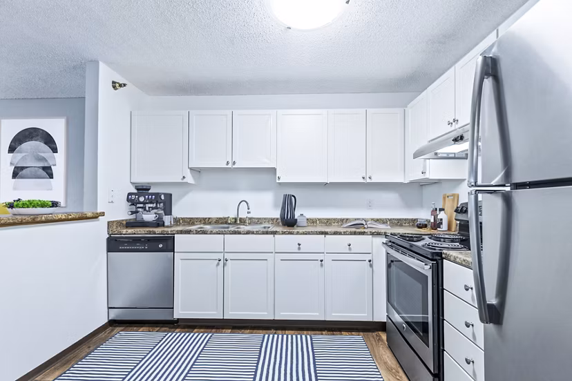 Kitchens with modern appliances and sleek countertops at Avana West Park Apartments