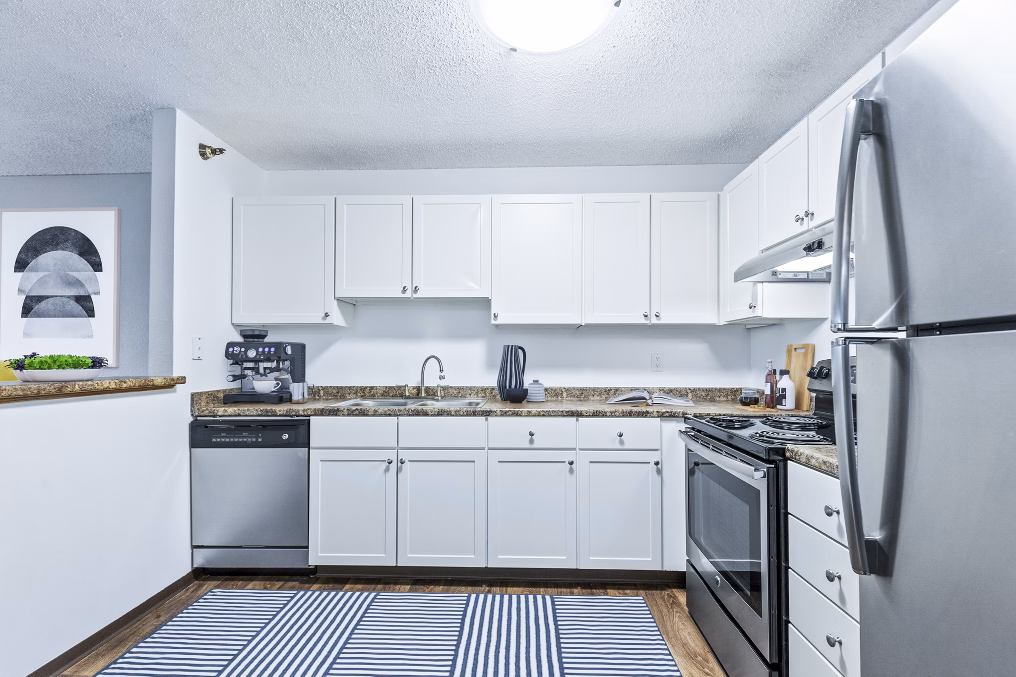 Kitchens with modern appliances and sleek countertops at Avana West Park Apartments