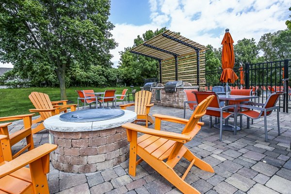Cozy fire pit and grill area at Avana West Park Apartments offering outdoor relaxation and entertainment space for residents