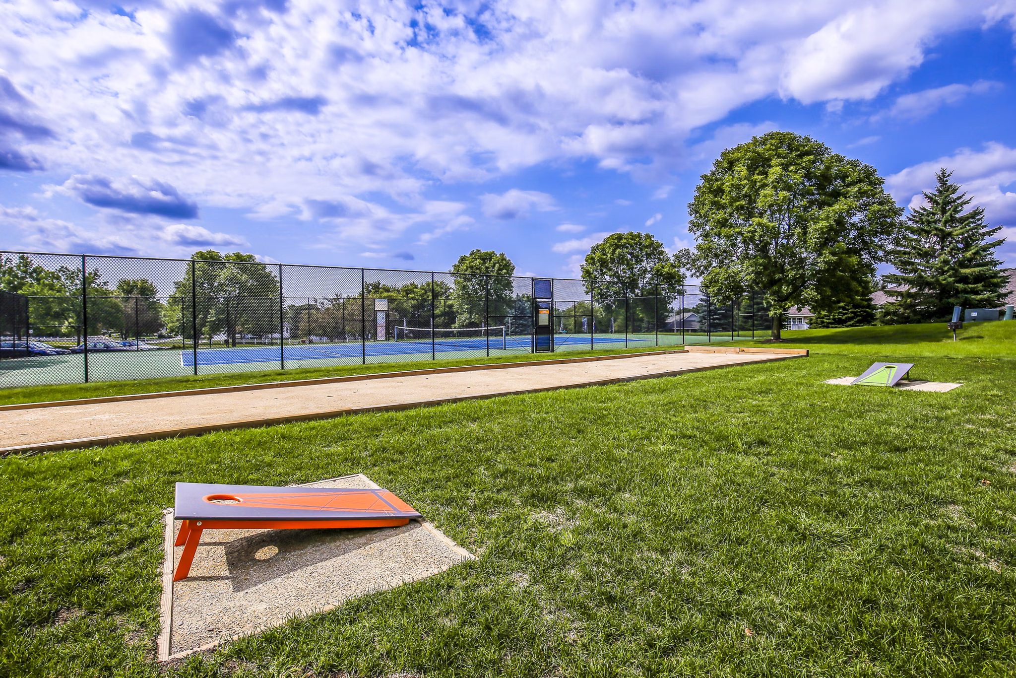 Outdoor sport courts at Avana West Park Apartments featuring basketball and tennis facilities for active living enthusiasts